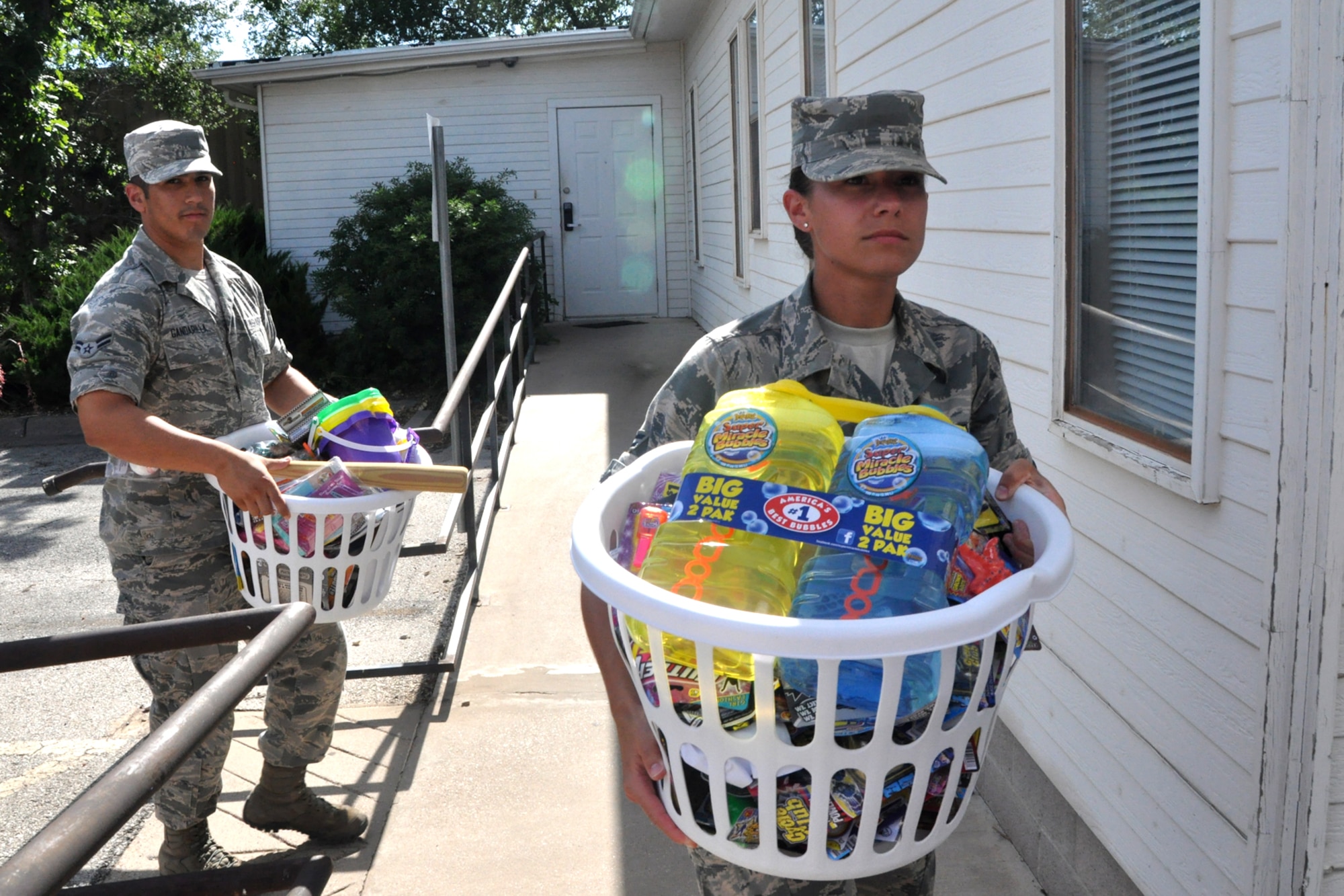 SAN ANGELO, Texas – Airman 1st Class Lorenzo Gandarilla and Airman 1st Class Amanda Kurtz, 315th Training Squadron students, carry baskets into the Children’s Advocacy Center of Tom Green County during a donation drop-off July 1. The 315th TRS students donated more than 1,000 items to the CAC of Tom Green County. (U.S. Air Force photo/ Airman 1st Class Breonna Veal)