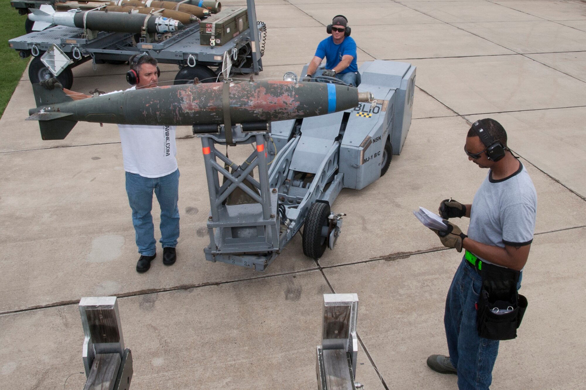 U.S. Air Force Tech. Sgt. Tony Rodriguez, Staff Sgt. Stacy Browne and Tech. Sgt. Phillip Hughes, load a training bomb onto a trailer after a munitions preparation inspection at Barksdale Air Force Base, La., June 26, 2014. All of the Airmen are aircraft armament systems technicians assigned to the 307th Aircraft Maintenance Squadron. Hughes, the team chief, is responsible for ensuring munitions are loaded properly and checklist procedures are followed. (U.S. Air Force photo by Master Sgt. Jeff Walston/Released) 