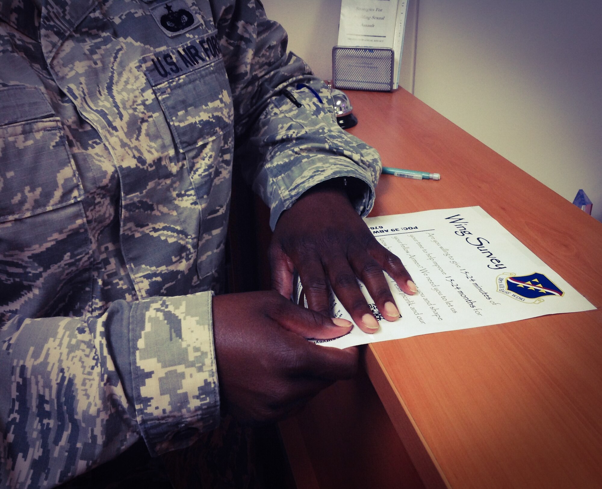 An Airman removes a tab off a flier advertising the 39th Air Base Wing survey June 27, 2014, Incirlik Air Base, Turkey. The consolidated information from the wing survey responses has been distributed to all the groups and tenant units on base. The feedback received will be assessed by subject matter experts who will determine how to best use the data collected to improve base services. (U.S. Air Force photo by Staff Sgt. Veronica Pierce/Released) 