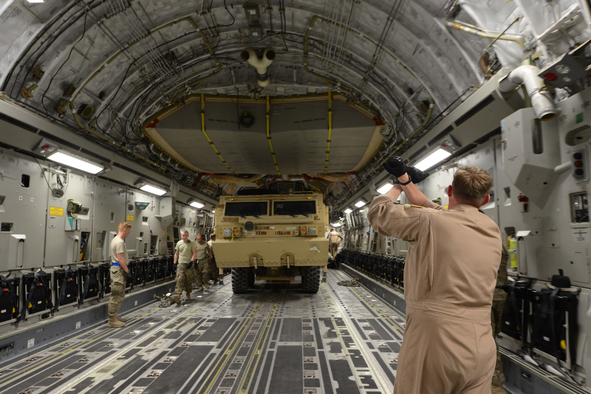 U.S. Air Force Tech. Sgt. Tim Raymon, a loadmaster assigned to the 385th Air Expeditionary Group, Detachment 1, Al Udeid, Qatar, signals the driver of a Heavy Expanded Mobility Tactical Truck to stop after driving onto a C-17 Globemaster III at Bagram Airfield, Afghanistan June 21, 2014. The HEMTT vehicle will be strapped into placed and redeployed. Raymon, a native of Jacksonville, Fla. and is deployed from McChord Air Force Base, Wash. (U.S. Air Force photo by Master Sgt. Cohen A. Young/Released)