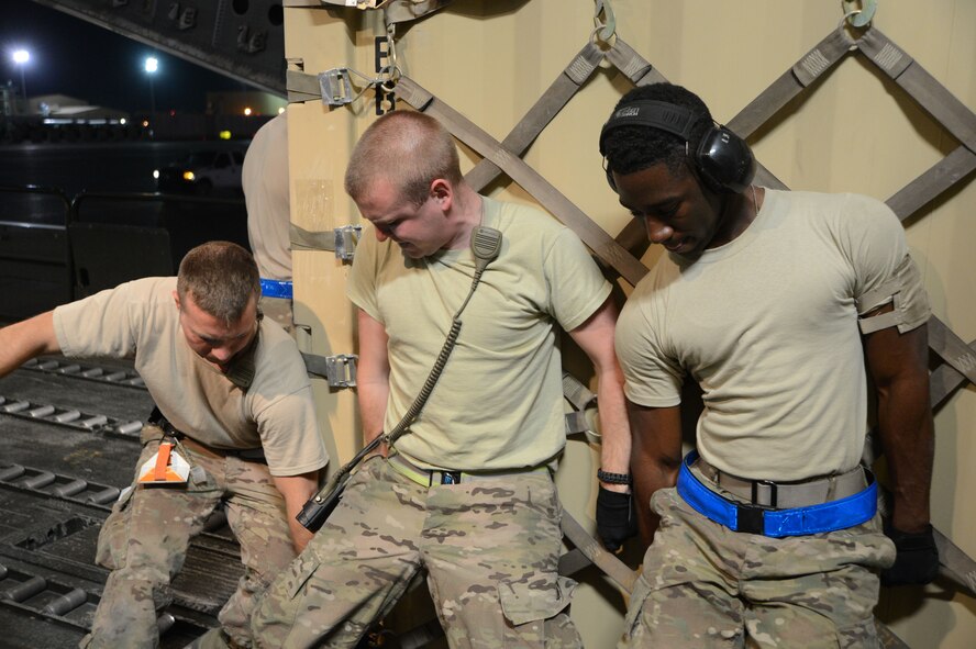 Airmen assigned to the 455th Expeditionary Aerial Port Squadron work together to move a pallet forward onto a C-17 Globemaster III June 21, 2014, at Bagram Airfield, Afghanistan. (U.S. Air Force photo/Master Sgt. Cohen Young)