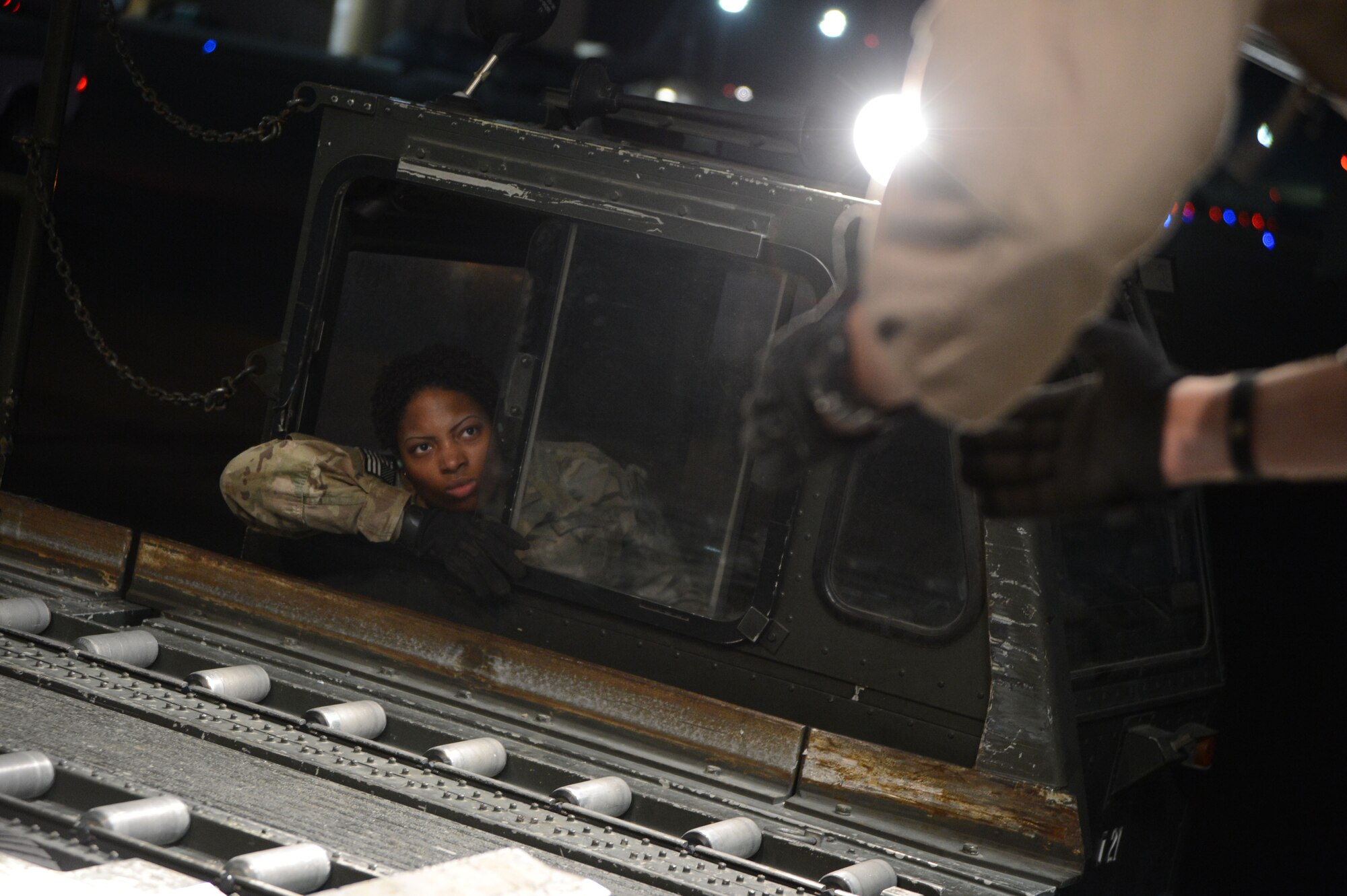 U.S. Air Force Airman 1st Class Candace Thompson, a native of Washington, D.C. and a cargo processor assigned to the 455th Expeditionary Aerial Port Squadron operates a K-loader vehicle as she watches the hands of a loadmaster as he guides her toward the rear of a C-17 Globemaster III prior to loading cargo and two Mine Resistant Ambush Protected vehicles at Bagram Airfield, Afghanistan June 21, 2014. Thompson is deployed from the 436th Aerial Port Squadron, Dover Air Force Base, De. The cargo and MRAPS are being redeployed to the U.S.  (U.S. Air Force photo by Master Sgt. Cohen A. Young/Released)