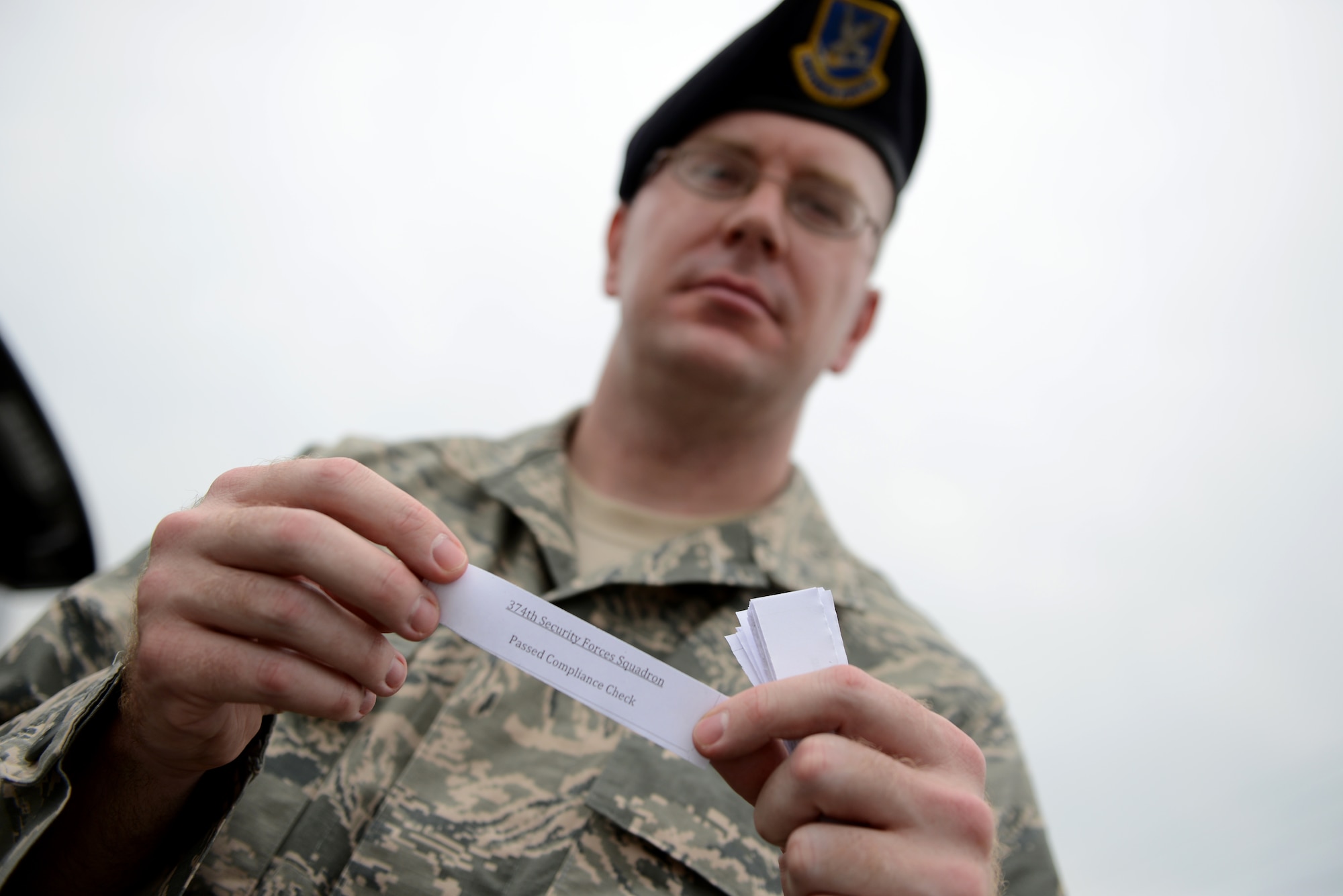 Tech. Sgt Davy Hoffman, 374th Security Forces Squadron unit resource advisor, displays a pass given to members who passed random check points during a traffic safety surge at Yokota Air Base, Japan, July 3, 2014. Drivers received the passes to avoid future check points if they had their vehicle documents in order and were driving safely and legally.  (U.S. Air Force photo by Staff Sgt. Cody H. Ramirez/Released)