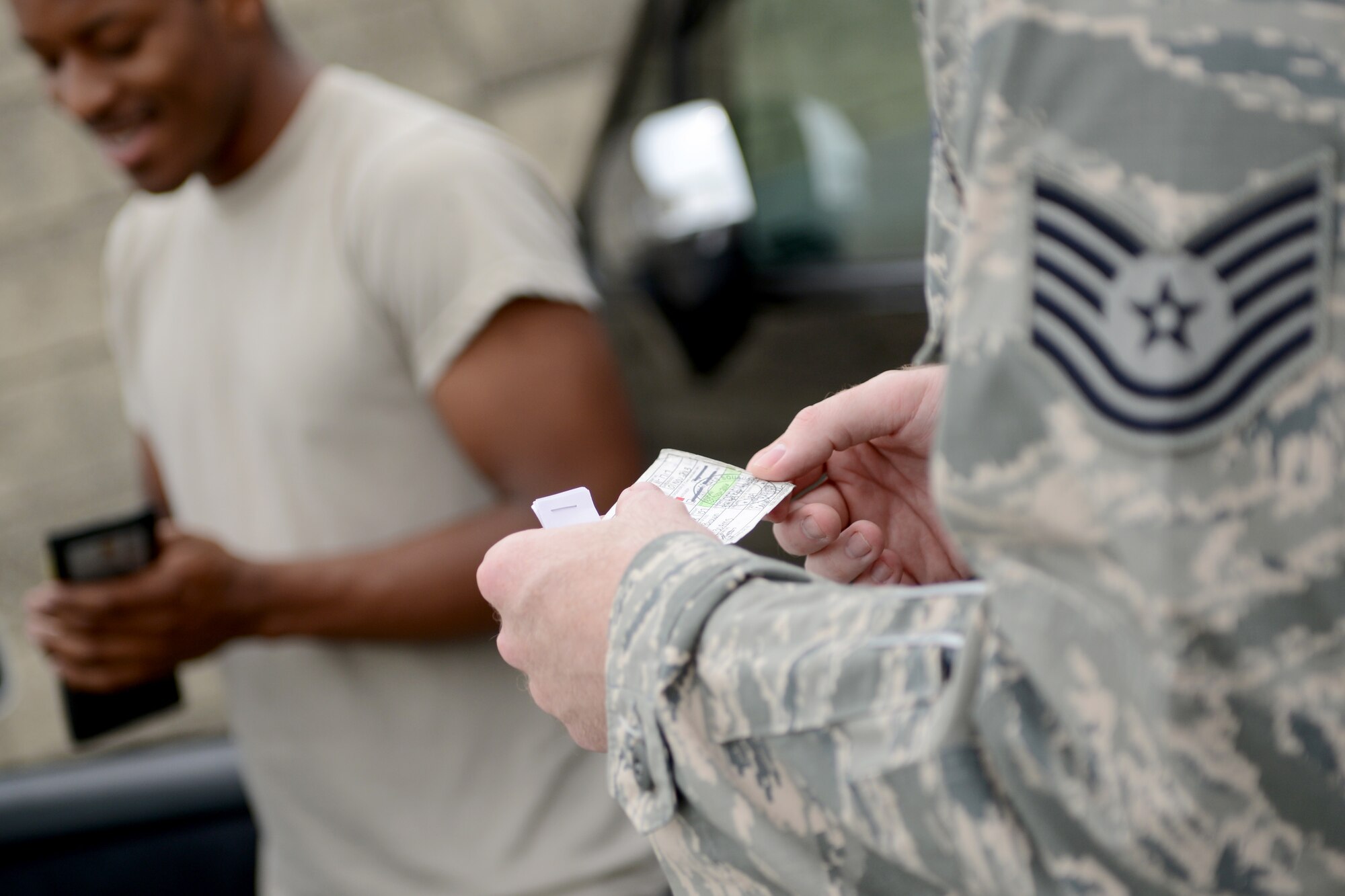Tech. Sgt. Davy Hoffman, 374th Security Forces Squadron unit resource advisor, checks a U.S. Forces, Japan, operator’s permit for a civilian vehicle during a traffic safety surge at Yokota Air Base, Japan, July 3, 2014. The traffic safety surge was intended to ensure the Yokota community was driving legally and safely before the long holiday weekend. (U.S. Air Force photo by Senior Airman Cody H. Ramirez/Released)