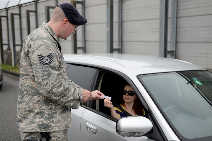Tech. Sgt. Davy Hoffman, 374th Security Forces Squadron unit resource advisor, hands a ‘Passed Compliance Check” card to a driver after checking her vehicle documents at Yokota Air Base, Japan, July 3, 2014. Hoffman was one of more than 20 SFS members who currently fill office jobs, but worked as patrolmen for the day to ensure Yokota members were driving safely and legally before the long weekend. (U.S. Air Force photo by Staff Sgt. Cody H. Ramirez/Released)