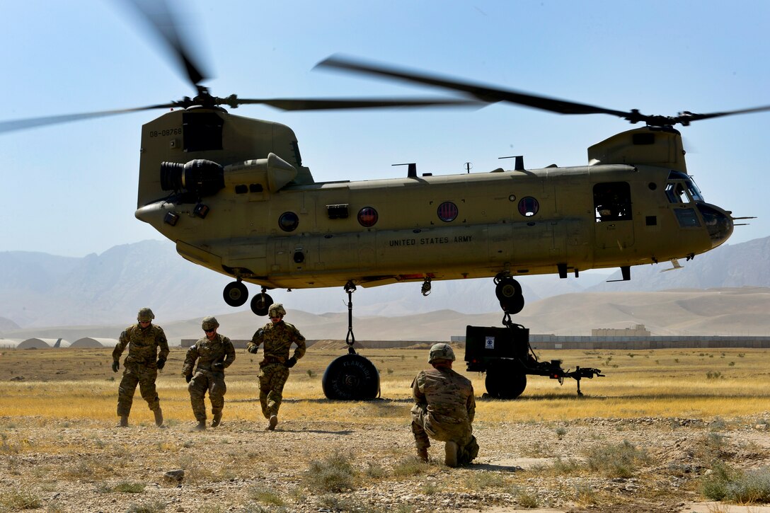 U.S. soldiers clear a CH-47 Chinook helicopter after hooking up a ...