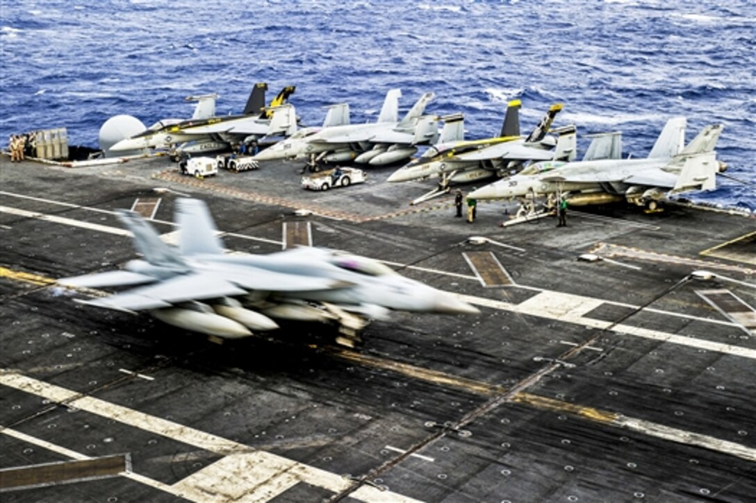 An F/A-18E Super Hornet makes an arrested landing on the flight deck of the aircraft carrier USS George Washington at sea, July 7, 2014. The ship and Carrier Air Wing 5, an embarked unit, provide a combat-ready force to protect and defend the maritime interest of the U.S. and its allies and partners in the Indo-Asia-Pacific region. The Hornet is assigned to the Eagles of Strike Fighter Squadron 115. 