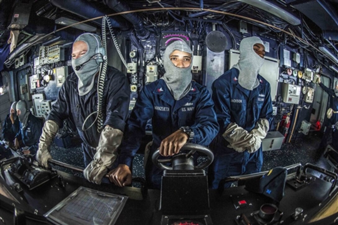 U.S. Navy sailors man the helm in the bridge of the guided-missile destroyer USS Kidd during a general quarters drill in the South China Sea, July 5, 2014. The Kidd is on patrol in the U.S. 7th Fleet area of responsibility supporting regional security and stability in the Indo-Asia Pacific region. 