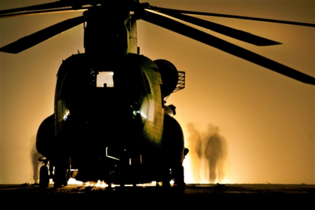 U.S. soldiers prepare a CH-47F Chinook helicopter before conducting the night portion of slingload training on Camp Marmal, Afghanistan, June 30, 2014. The soldiers are crew chiefs assigned to Company B, 1st Battalion, 169th General Support Aviation Battalion. 