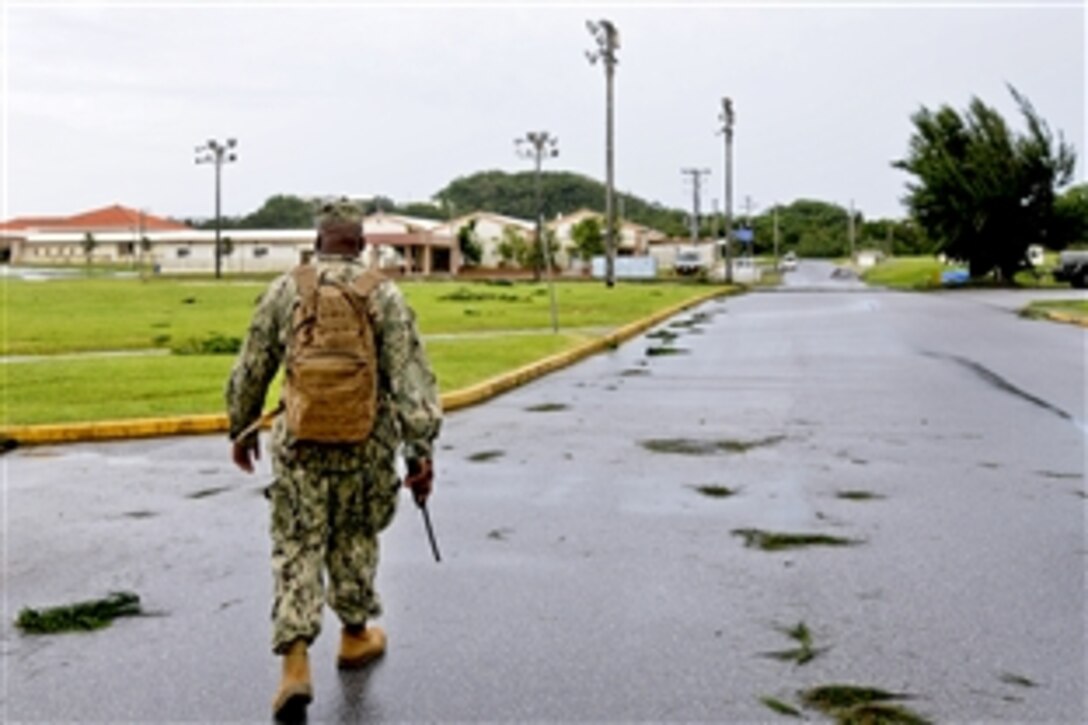 A U.S. sailor assesses damage to Camp Shields, Japan, July 9, 2014, after Super Typhoon Neoguri struck Okinawa, Japan, July 8. The sailors are assigned to Naval Mobile Construction Battalion 1.