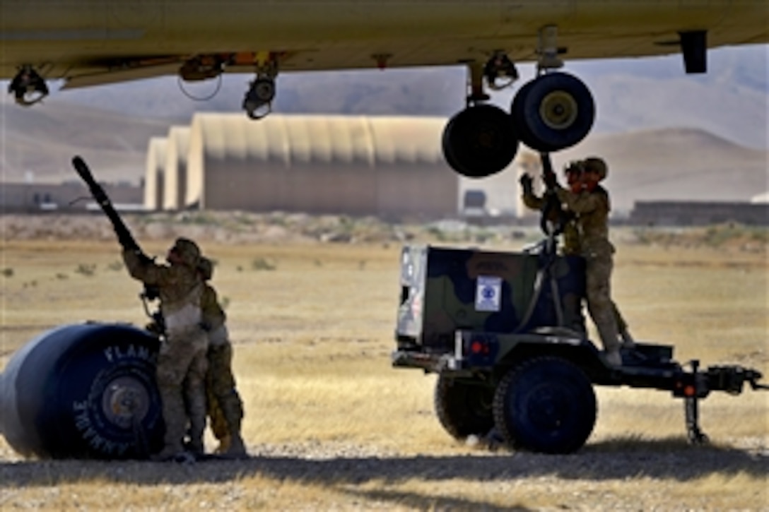 U.S. soldiers hook up a slingload to a CH-47 Chinook helicopter on Camp Marmal, Afghanistan, July 1, 2014. The soldiers who hooked up the slingload are assigned to the 1569th Transportation Company, and the helicopter crew members who provided support are assigned to Company B, 1st Battalion, 169th General Support Aviation Battalion.
