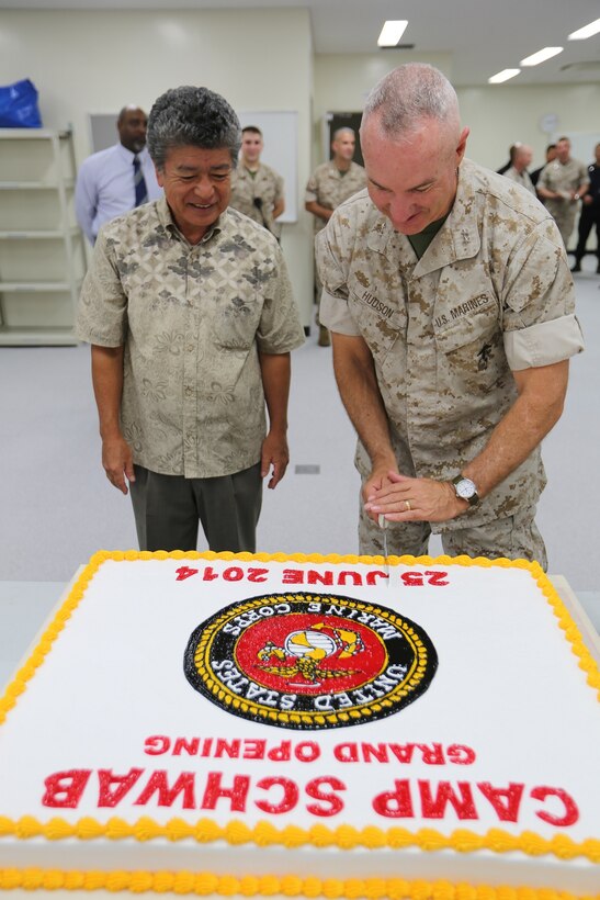 U.S. Marine Maj. Gen. Charles L. Hudson, right, cuts a piece of ceremonial cake for Munekatsu Kayo June 25 at Camp Schwab in celebration of the opening of a new visitor center and entrance gate. “I think this will have a positive impact on the community because now it is easier for Okinawa residents to see the camp and interact with the Marines,” said Kayo, the mayor of Henoko. Hudson is the commanding general of Marine Corps Installations Pacific. (U.S. Marine Corps photo by Lance Cpl. Matt Myers/Released) 