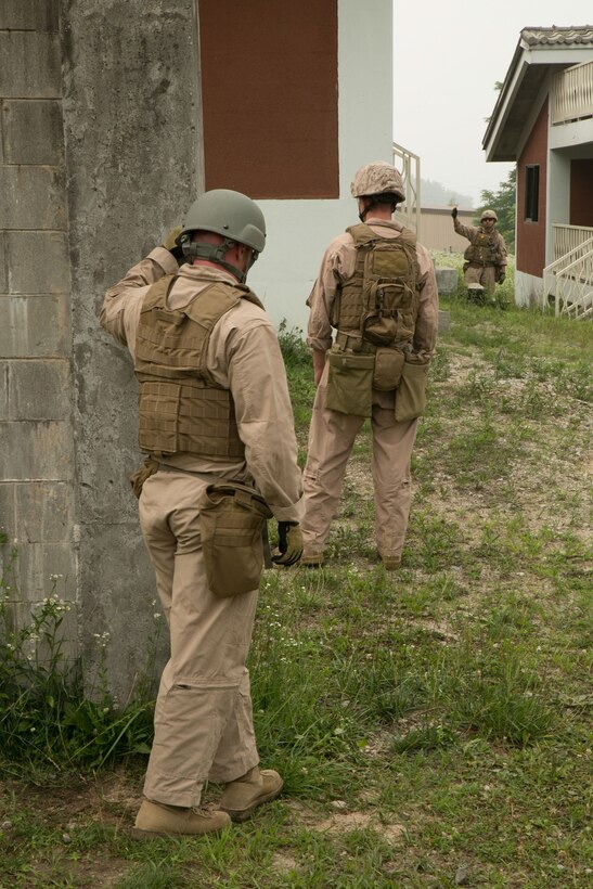 Explosive ordnance disposal technicians prepare to enter a building with a simulated weapons cache June 25 during Dragon Crab, a three-day exercise at the Rodriguez Live-Fire Complex. The EOD technicians cut trip wires before entering the building. The scenario is one of eight that tests the skills of U.S. Marine and Army EOD technicians. The Marines are with 9th Engineer Support Battalion, 3rd Marine Logistics Group, III Marine Expeditionary Force.