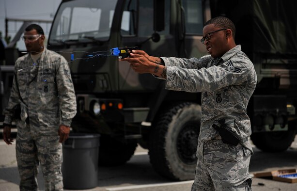 Senior Airman Marcus Thomas fires a Taser during training June 27, 2014, on Osan Air Base, South Korea. The Taser fires two small dart-like electrodes which stay connected to the main unit by conductive wire while being propelled by small compressed nitrogen charges. Thomas is a 51st Security Forces Squadron entry controller. (U.S. Air Force photo/Senior Airman David Owsianka)