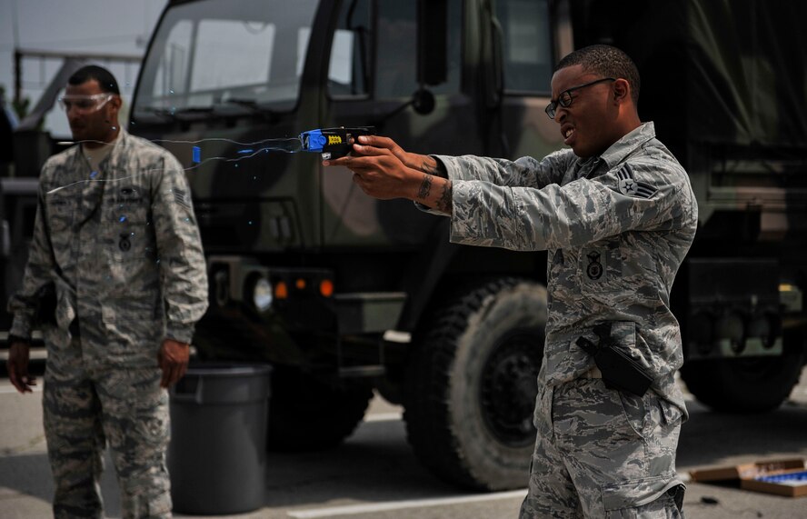 Senior Airman Marcus Thomas fires a Taser during training June 27, 2014, on Osan Air Base, South Korea. The Taser fires two small dart-like electrodes which stay connected to the main unit by conductive wire while being propelled by small compressed nitrogen charges. Thomas is a 51st Security Forces Squadron entry controller. (U.S. Air Force photo/Senior Airman David Owsianka)
