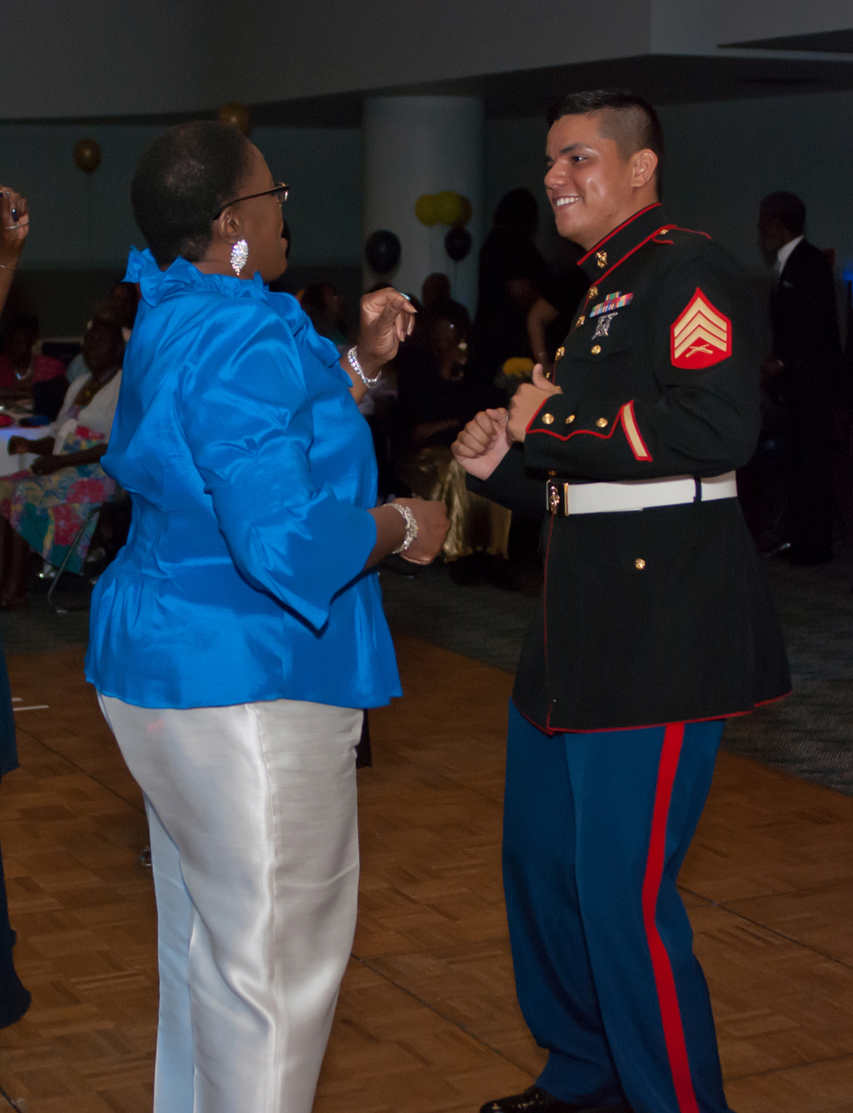 Sgt. Thomas Over, licensing noncommissioned officer, Logistics Support Division, Marine Corps Logistics Base Albany, dances with an attendee during the Senior Prom, June 20 at the Albany James H. Gray Sr. Civic Center in Albany, Georgia.
