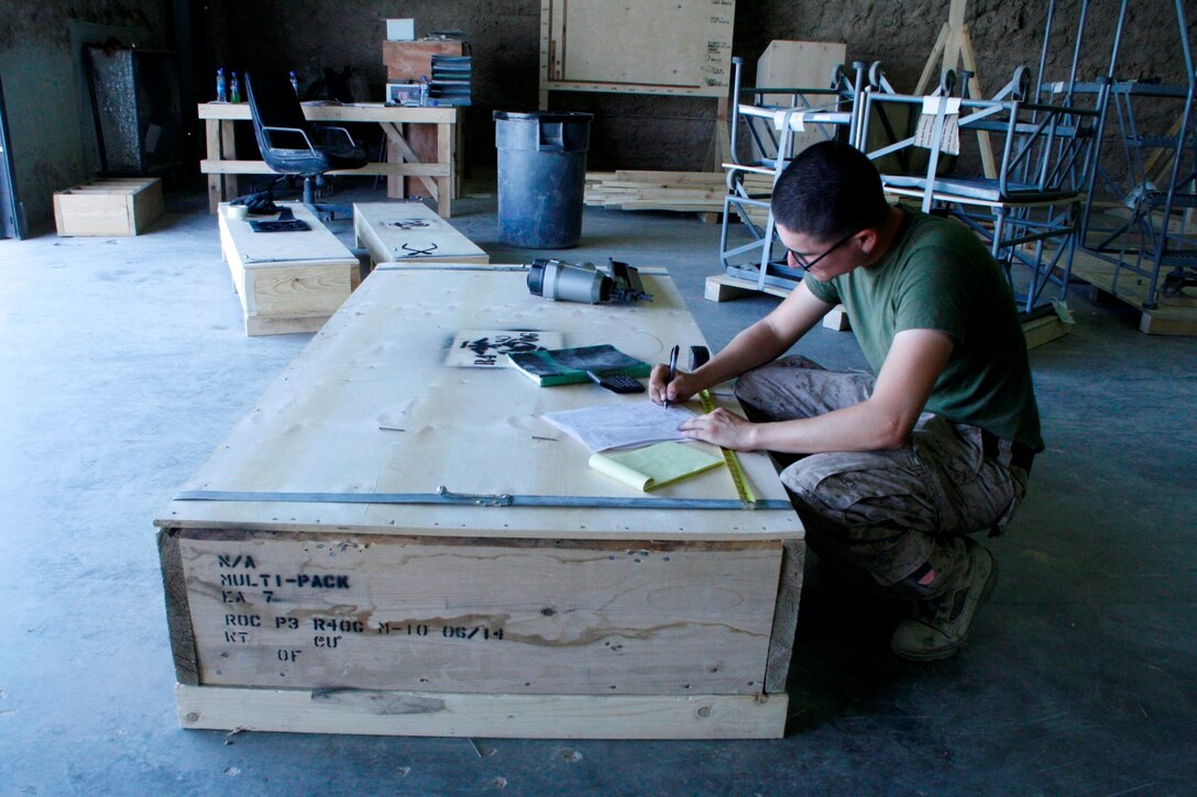 Corporal Jonathan Arevalo, a preservation, packaging and packing specialist with Redeployment and Retrograde in support of Reset and Reconstitution Operations Group, checks and records the dimensions of a box used for retrograding gear back to the United States, aboard Camp Leatherneck, Helmand province, Afghanistan, July 1, 2014. R4OG was established during April 2012 and has a significant role as the unit responsible for bringing all Marine Corps gear home from Afghanistan.