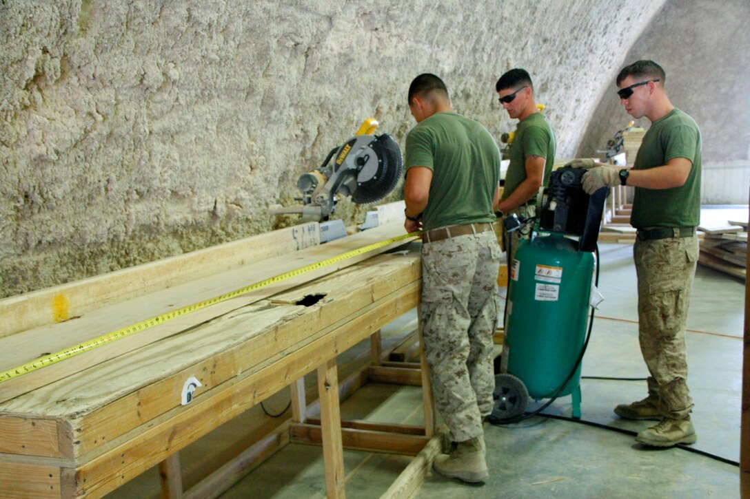 Marines with Redeployment and Retrograde in support of Reset and Reconstitution Operations Group cut and measure pieces of wood used to build boxes for retrograding equipment aboard Camp Leatherneck, Helmand province, Afghanistan, July 1, 2014. R4OG was established during April 2012 and has a significant role as the unit responsible for bringing all Marine Corps gear home from Afghanistan.