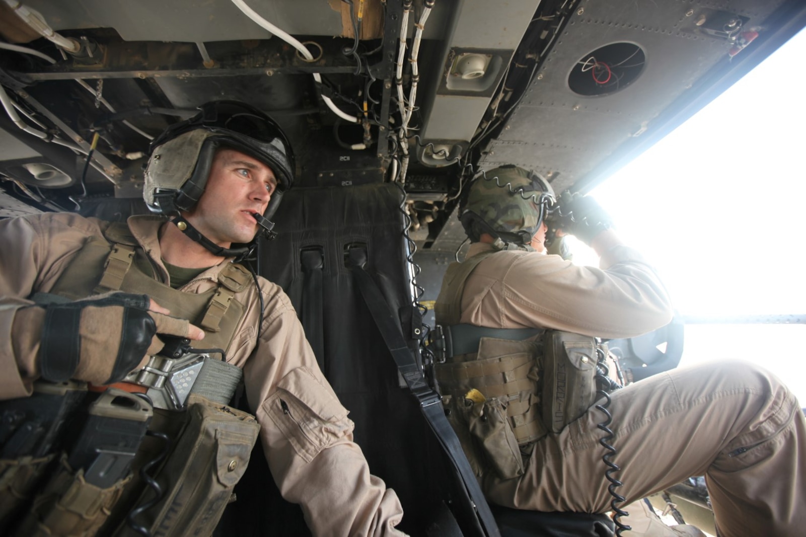 Staff Sgt. Jonathan Lee, left, and Staff Sgt. Kenneth Morris, both crew chiefs with Marine Light Attack Helicopter Squadron 467, watch for any suspicious activity on the ground during a mission in Helmand province, Afghanistan, July 3, 2014. Marine Light Attack Helicopter Squadron 467 was established five years ago aboard Marine Corps Air Station Cherry Point, N.C., and is on their first combat deployment as a squadron. The Marines of HMLA-467 will be the last Marines to conduct close-air support operations in Afghanistan in support of Operation Enduring Freedom. (U.S. Marine Corps Photo By: Sgt. Frances Johnson/Released)