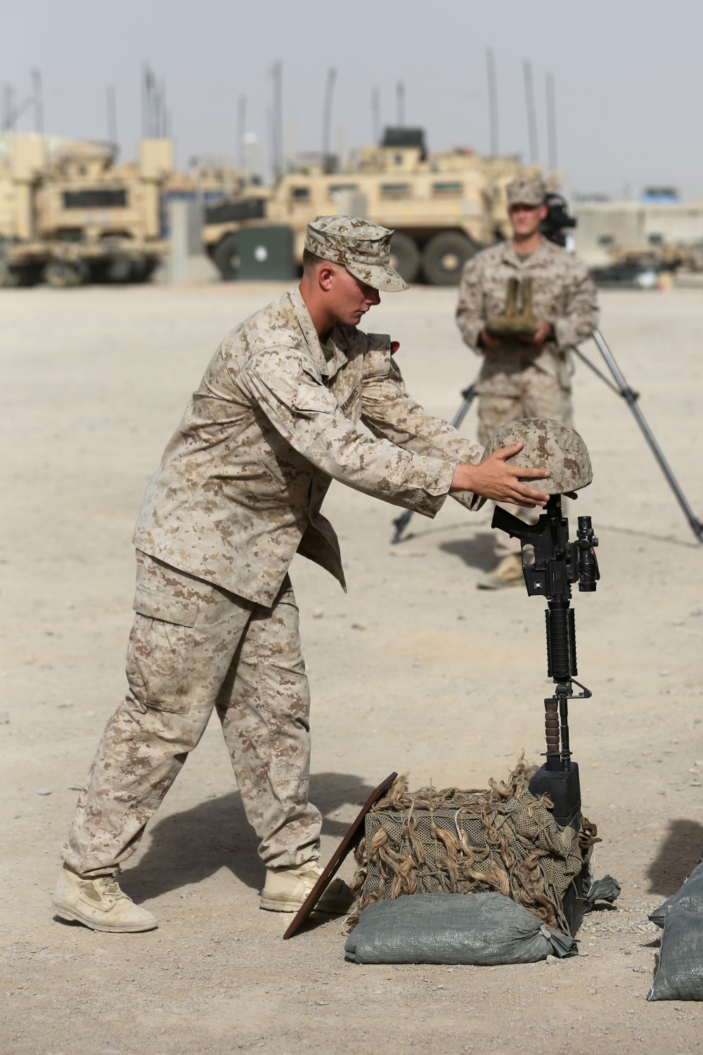 Corporal Ryan Pettis, scout sniper, Scout Sniper Platoon, 1st Battalion, 7th Marine Regiment, and a native of Pueblo, Colorado, places a Kevlar helmet on a battlefield cross during a memorial ceremony aboard Camp Leatherneck, July 2, 2014. The memorial was in honor of Sgt. Thomas Z. Spitzer, a professionally instructed gunman with Scout Sniper Platoon, 1st Bn., 7th Marines, who was killed while conducting combat operations in Helmand province, Afghanistan, June 25, 2014.
(U.S. Marine Corps photo by Cpl. Joseph Scanlan / released)