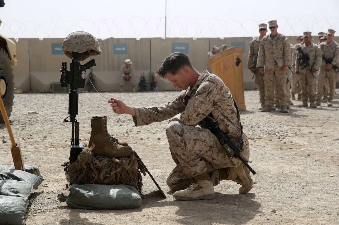 Sergeant Louis Wood, scout sniper, Scout Sniper Platoon, 1st Battalion, 7th Marine Regiment, and a native of Fort Worth, Texas, pays his respects to Sgt. Thomas Z. Spitzer during a memorial ceremony aboard Camp Leatherneck, July 2, 2014. The memorial was in honor of Spitzer, a professionally instructed gunman with Scout Sniper Platoon, 1st Bn., 7th Marines, who was killed while conducting combat operations in Helmand province, Afghanistan, June 25, 2014. (U.S. Marine Corps photo by Cpl. Joseph Scanlan / released)
