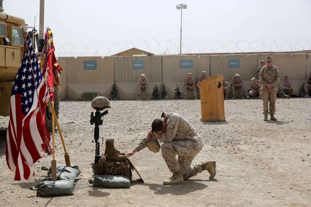 Captain Deed Ziegler, an intelligence officer and platoon commander for Scout Sniper Platoon, 1st Battalion, 7th Marine Regiment, and a native of Albany, California, pays his respects to Sgt. Thomas Z. Spitzer during a memorial ceremony aboard Camp Leatherneck, July 2, 2014. The memorial was in honor of Spitzer, a professionally instructed gunman with Scout Sniper Platoon, 1st Bn., 7th Marines, who was killed while conducting combat operations in Helmand province, Afghanistan, June 25, 2014. (U.S. Marine Corps photo by Cpl. Joseph Scanlan / released)