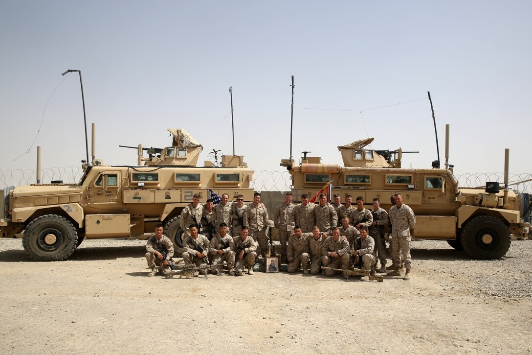 Marines with Scout Sniper Platoon, 1st Battalion, 7th Marine Regiment, pose for a photo around a battlefield cross after a memorial ceremony aboard Camp Leatherneck, July 2, 2014. The memorial was in honor of Sgt. Thomas Z. Spitzer, a professionally instructed gunman with Scout Sniper Platoon, 1st Bn., 7th Marines, who was killed while conducting combat operations in Helmand province, Afghanistan, June 25, 2014. (U.S. Marine Corps photo by Cpl. Joseph Scanlan / released)