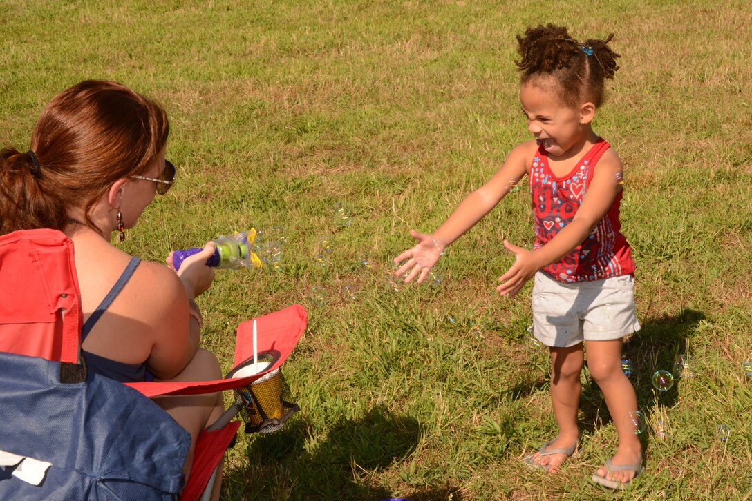 Alayjah, 2, screeches in excitement as Nancy Bentley, her mother, sends bubbles her way during the Independence Day celebration on Lejeune Field July 14, 2014.