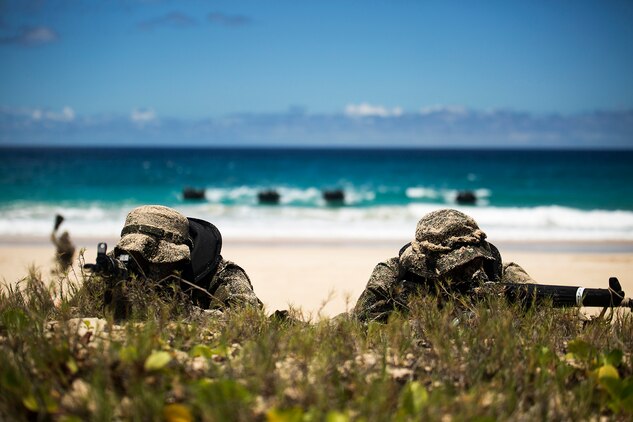 Two soldiers with the Japan Ground Self-Defense Force (JGSDF) provide security while the rest of their team moves to shore during an amphibious assault at Pyramid Rock Beach. The JGSDF conducted the training exercise with U.S. Marines with 3rd Reconnaissance Battalion, based in Okinawa, Japan. The world's largest international maritime exercise, Rim of the Pacific (RIMPAC) Exercise 2014, provides a unique training opportunity that helps participants foster and sustain the cooperative relationships that are critical to ensuring the safety of sea lanes and security on the world's oceans. Twenty-two nations, more than 40 ships, six submarines, more than 200 aircraft and 25,000 personnel are participating in RIMPAC.