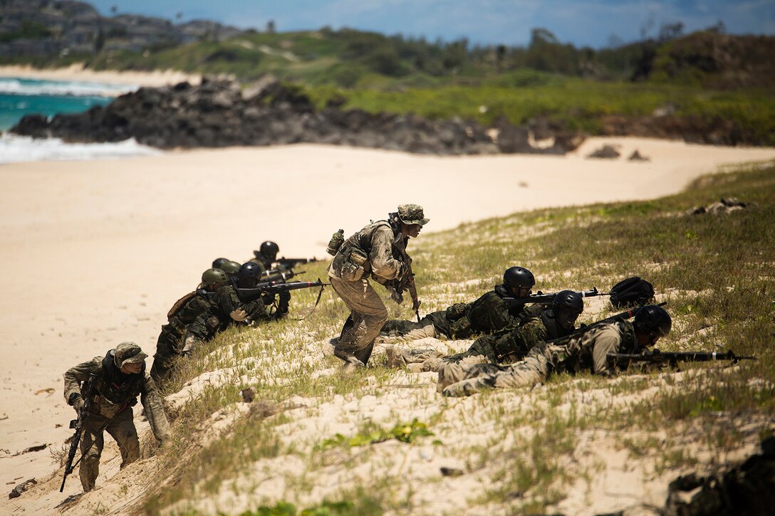 Two Japan Ground Self-Defense Force soldiers (left and center) advance to cover while their squads provide cover during an amphibious assault at Pyramid Rock Beach. The JGSDF conducted the training exercise with U.S. Marines with 3rd Reconnaissance Battalion, based in Okinawa, Japan. The world's largest international maritime exercise, Rim of the Pacific (RIMPAC) Exercise 2014, provides a unique training opportunity that helps participants foster and sustain the cooperative relationships that are critical to ensuring the safety of sea lanes and security on the world's oceans. Twenty-two nations, more than 40 ships, six submarines, more than 200 aircraft and 25,000 personnel are participating in RIMPAC.