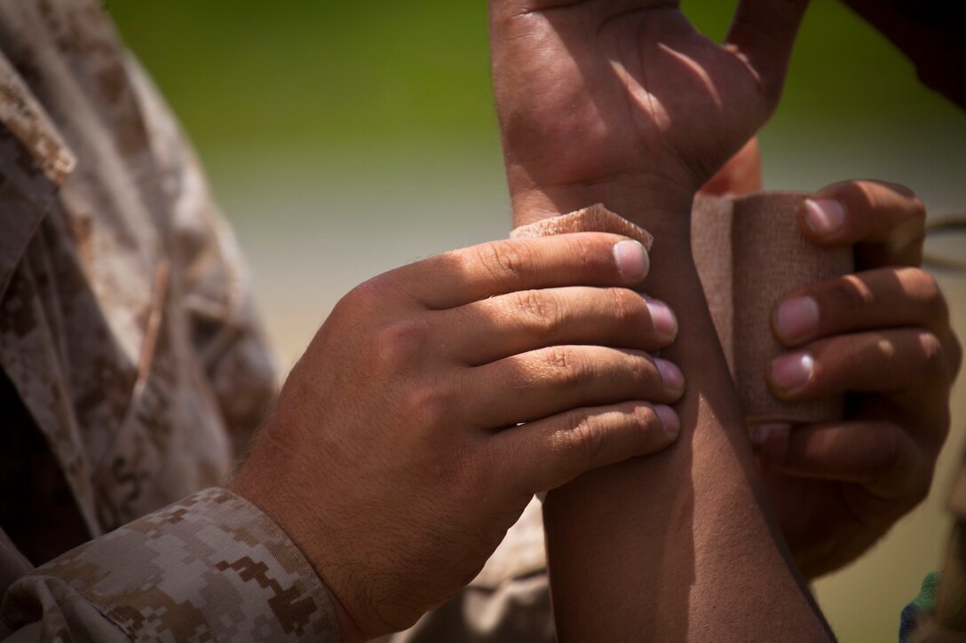 U.S. Navy Hospitalman Aaron Keck (left), attached to Lima Company, 3rd Battalion, 3rd Marine Regiment, treats a rope burn on a Malaysian Soldier after fast roping off a CH-53E Super Stallion during Rim of the Pacific (RIMPAC) Exercise 2014 at Landing Zone Eagle. Twenty-two nations, 49 ships, 6 submarines, more than 200 aircraft and 25,000 personnel are participating in RIMPAC from June 26 to Aug. 1, in and around the Hawaiian Islands and Southern California. The world's largest international maritime exercise, RIMPAC provides a unique training opportunity that helps participants foster and sustain the cooperative relationships that are critical to ensuring the safety of sea lanes and security on the world's oceans. RIMPAC 2014 is the 24th exercise in the series that began in 1971.
