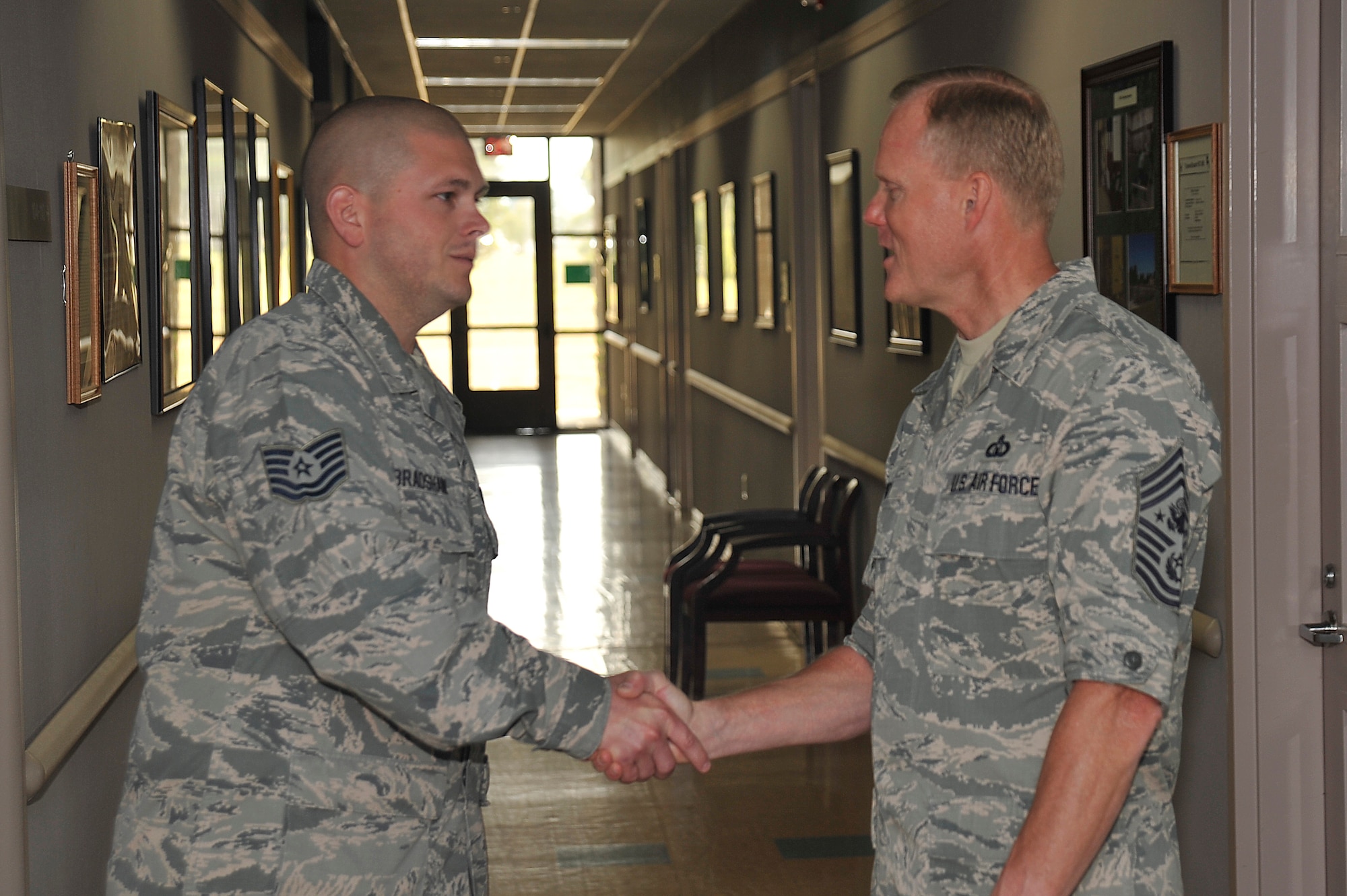 Chief Master Sgt. of the Air Force, James A. Cody, coins Technical Sgt. Christopher Bradshaw, 532nd Training Squadron instructor supervisor, for Bradshaw's superior performance and wingmanship July 8, 2014, Vandenberg Air Force Base, Calif. (U.S. Air Force photo by Michael Peterson/Released)