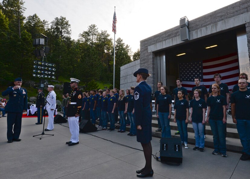 Representatives from different military service branches present their recruits to Col. Kevin Kennedy, 28th Bomb Wing commander, to initiate their oath of enlistment into the military during an Independence Day celebration at Mount Rushmore National Memorial in South Dakota, July 3, 2014.  In addition to witnessing recruits swear to defend the Constitution, hundreds of people were treated to a night filled with patriotic music played by the U.S. Air Force Academy Concert Band. (U.S. Air Force photo by Senior Airman Anania Tekurio/Released)