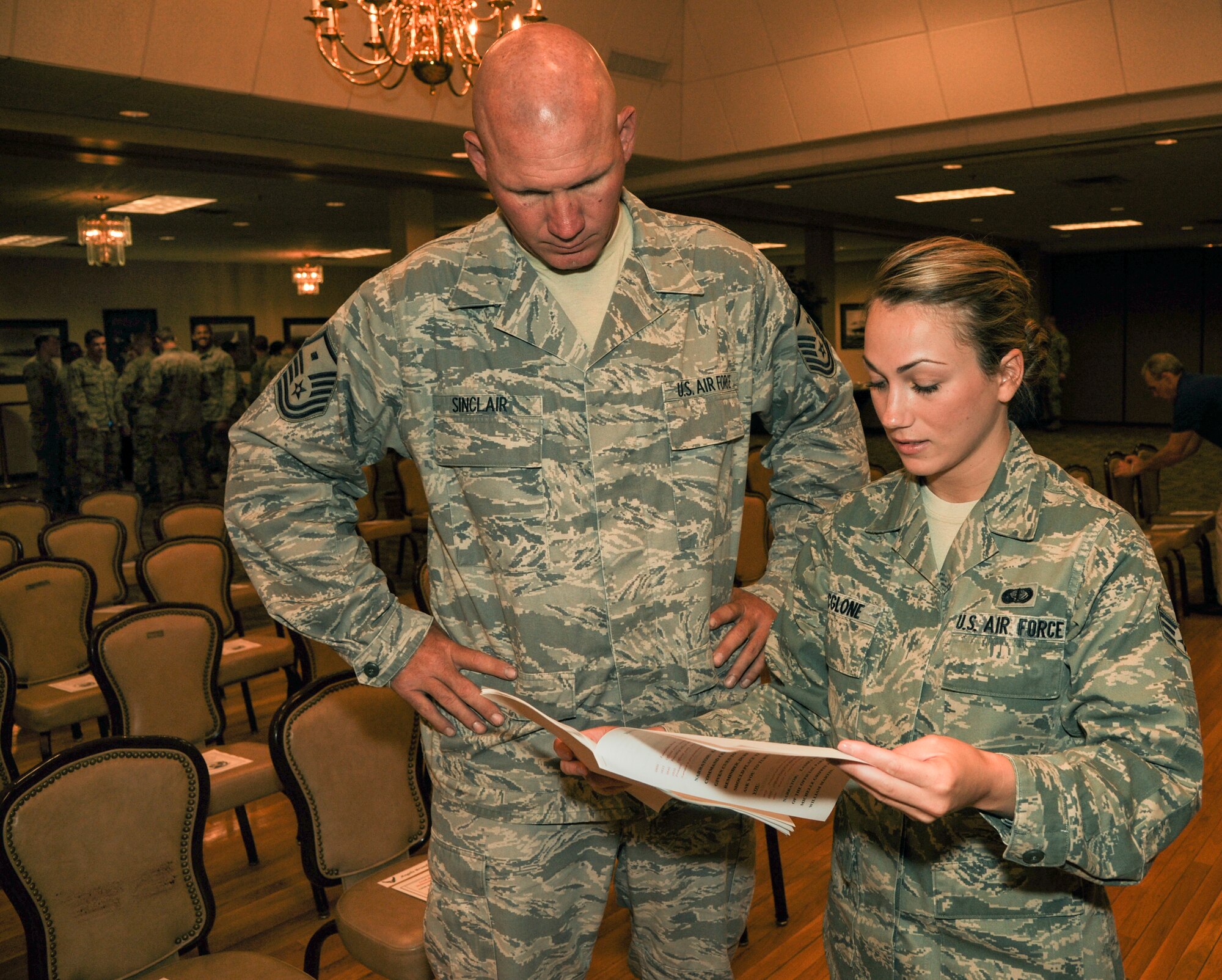 Senior Airman Katy McGlone, 19th Airlift Wing Protocol assistant reviews event plans with Master Sgt. Adam Sinclair, 314th Aircraft Maintenance Squadron first sergeant, for the 314th Aircraft Maintenance Squadron change of command ceremony July 8, 2014, at Little Rock Air Force Base, Ark. McGlone has been instrumental in the behind-the-scenes support of distinguished visitor tours to three wings and all base tenants. (U.S. Air Force photo by Airman 1st Class Harry Brexel)