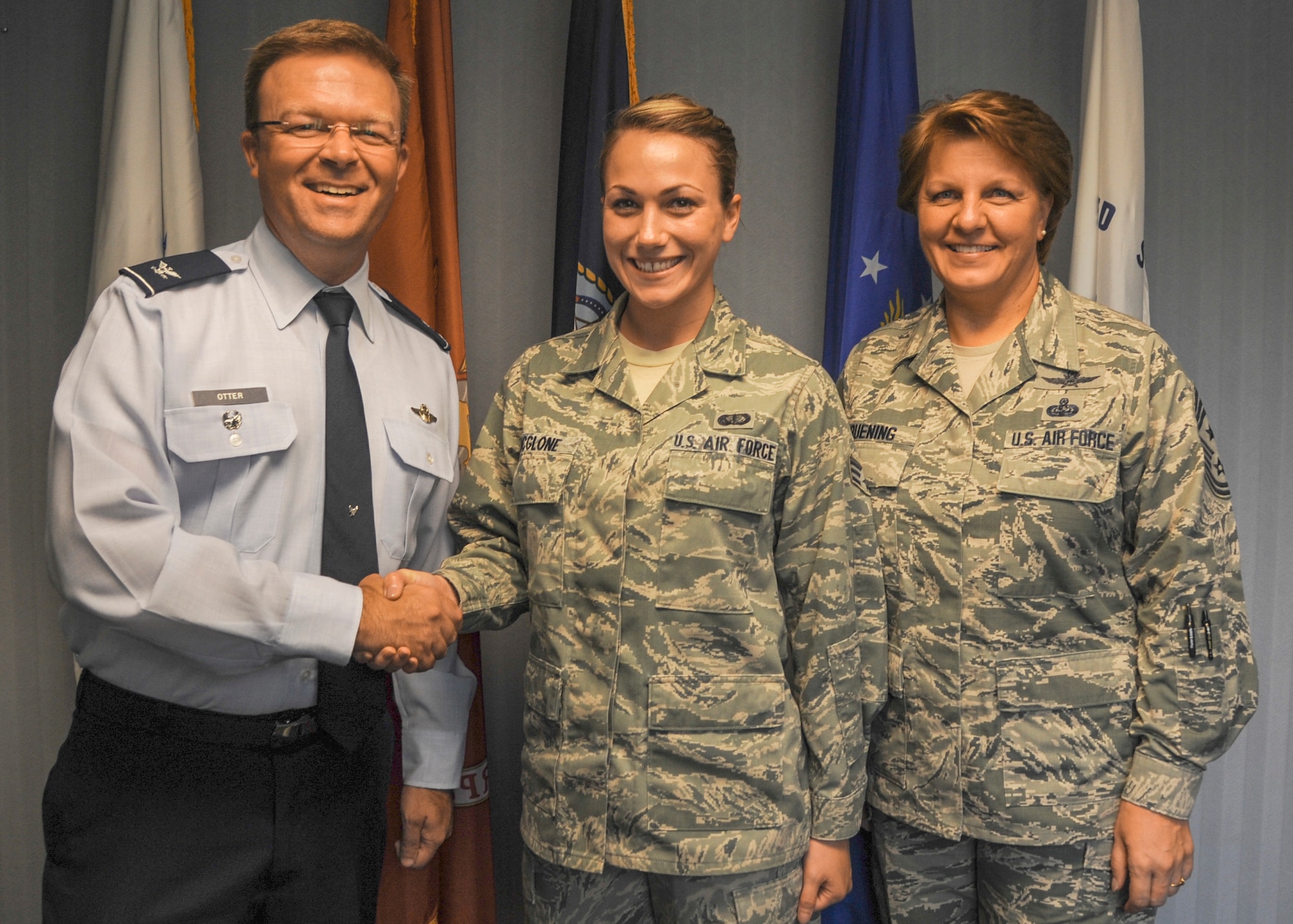 Col. William Otter, 19th Airlift Wing vice commander, and Chief Master Sgt. Rhonda Buening, 19th AW command chief, congratulate Senior Airman Katy McGlone, 19th Airlift Wing Protocol assistant, as Combat Airlifter of the Week July 7, 2014, at Little Rock Air Force Base, Ark. McGlone, an Omaha, Neb. native, has provided support for base visits from governors, senators, commanders and the President. (U.S. Air Force photo by Airman 1st Class Harry Brexel)