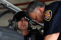 Jerry Knopf, Joint Base San Antonio-Randolph firefighter, instructs Herlin Pineda,  City of San Antonio Fire firefighter, how to secure the ejection seat of a T-6 Texan II before rescuing the pilot July 9, 2014 at JBSA-Randolph. The ejection seat of a T-6 Texan II makes it necessary for firefighters to take extra precautions when responding to an emergency involving the aircraft. By becoming familiar with the aircraft the firefighters will be better prepared for emergencies. (U.S. Air Force photos by A1C Stormy D. Archer/Released)