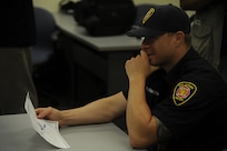 Ryan Edwards, City of San Antonio firefighter, reviews a diagram of a T-6 Texan II during a briefing July 9, 2014 at Joint Base San Antonio-Randolph. City of San Antonio firefighters received training from JBSA-Randolph firefighters on how to safely extricate crewmembers from a T-6 Texan II. The familiarization training is intended to bring firefighters together to prepare for emergencies. (U.S. Air Force photos by A1C Stormy D. Archer/Released)