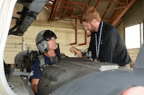 Jerry Knopf, Joint Base San Antonio-Randolph firefighter, trains Dawson L. Frank, San Antonio Airport interim airport emergency coordinator, during T-6 Texan II aircraft egress training July 09, 2014 at JBSA-Randolph. The firefighters received training on how to safely perform egress actions to ensure they know how to respond to any possible T-6 aircraft mishaps at the San Antonio International Airport. (U.S. Air Force photo by Johnny Saldivar)