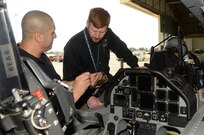 Tim Hagan, Joint Base San Antonio-Randolph firefighter, trains Dawson L. Frank, San Antonio International Airport interim airport emergency coordinator, during T-6 Texan II aircraft egress training July 09, 2014 at JBSA-Randolph. The firefighters received training on how to safely perform egress actions to ensure they know how to respond to any possible T-6 aircraft mishaps at the San Antonio International Airport. (U.S. Air Force photo by Johnny Saldivar)