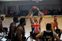 David Scott, center, shoots the basketball July 9, 2014, during 2014 Wounded Warrior Summer Invitational Adaptive Sports Tournament at the Rambler Fitness Center at Joint Base San Antonio-Randolph, Texas. The event features 100 wounded warriors from both the U.S. and the United Kingdom. The event is leading up to two other events beginning this September, which are the Warrior Games being held in Colorado Springs, Colorado, and the Invictus Games being held in the U.K. Scott is a player on the British Armed Forces team. The three-day event included skill development and tournament competition in wheelchair basketball and sitting volleyball for the wounded warriors from the U.S. Air Force, Army, Marine Corps and Great Britain.  (U.S. Air Force photo/Desiree N. Palacios)