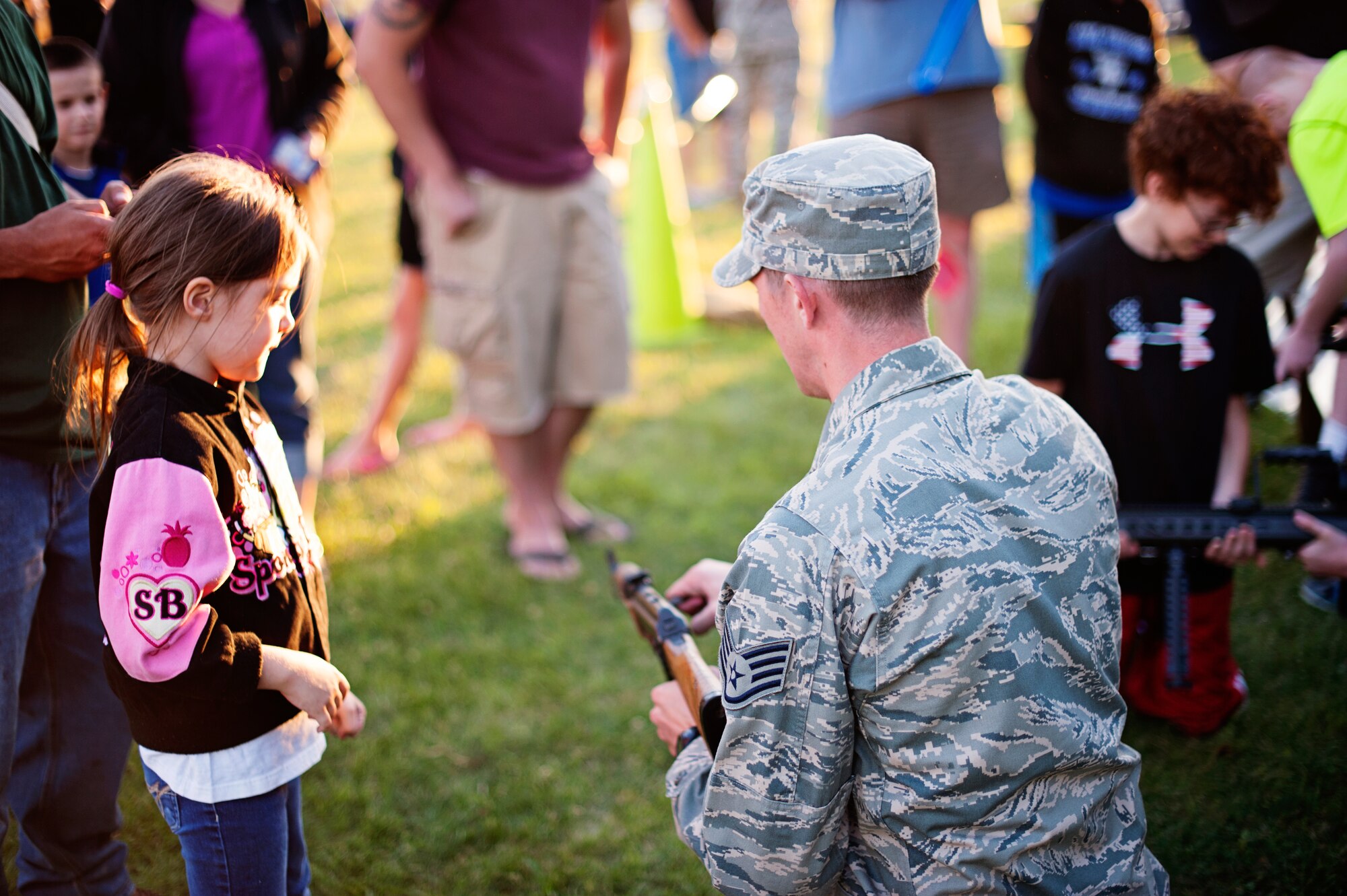 An 87th Civil Engineer Squadron explosive ordnance disposal technician demonstrates the use of a rifle to a child during Joint Base McGuire-Dix-Lakehurst’s 2014 Independence Day Open House held at Doughboy Field, July 4, 2014. Attendees got hands-on experience with military equipment, view static displays and explosives ordnance disposal gear. (U.S. Air Force photo/Staff Sgt. Katherine Tereyama)