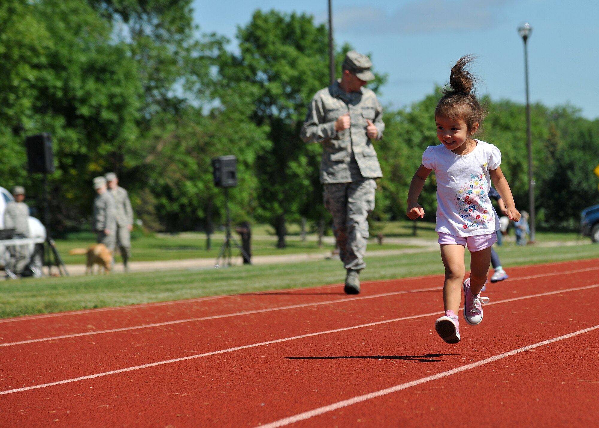 Ana Montes, daughter of Tech. Sgt. Jason Montes, 319th Logistics Readiness Squadron, runs toward the finish line for the 100 meter dash during a children’s segment of the Triple 8 Fitness Challenge on July 9, 2014, on Grand forks Air Force Base, N.D. During the Triple 8 Fitness Challenge, children enjoyed the bouncy castles, a dunking booth and free food for the families. (U.S. Air Force photo/Senior Airman Xavier Navarro)