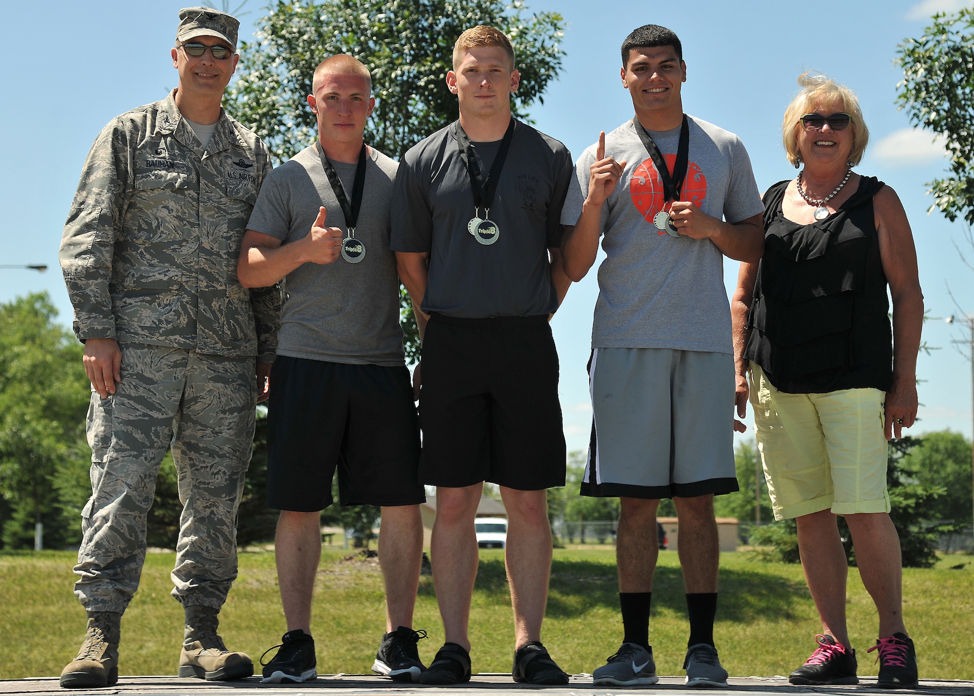 (left) Col. Paul Bauman, 319th Air Base Wing commander, congratulates members of the 319th Logistics Readiness Squadron team who placed first with 117 points in the Triple 8 Fitness Challenge July 9, 2014, on Grand Forks Air Force Base, N.D. The 319th LRS team completed 87 push-ups, 85 sit-ups and a 1.5-mile run in 8 minutes and 52 seconds, distinguishing them as an elite group that sets the fitness standard. (U.S. Air Force photo/Senior Airman Xavier Navarro)