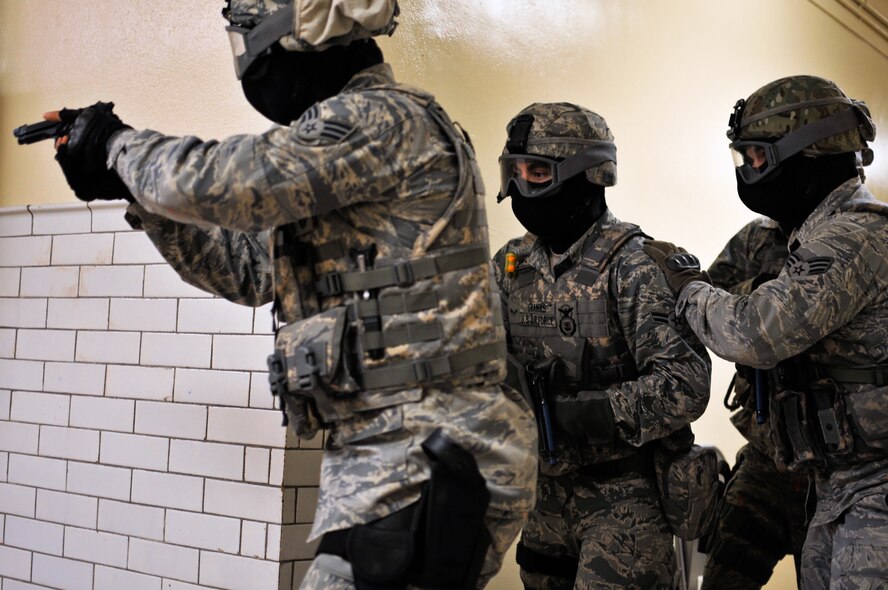 A response team with the 182nd Security Forces Squadron searches for a suspect after hearing gunfire during an active shooter training exercise in Peoria, Ill., June 11, 2014. The squadron trained with weapons loaded with paint ammunition to enhance their response skills. The Air Force defines an active shooter as someone actively trying to kill people, most often in populated areas. In most cases, active shooters use firearms, and there is no pattern to selecting victims. Valuable training on surviving an active shooter can be found at www.BeReady.af.mil. (U.S. Air National Guard photo by Staff Sgt. Lealan Buehrer/Released)