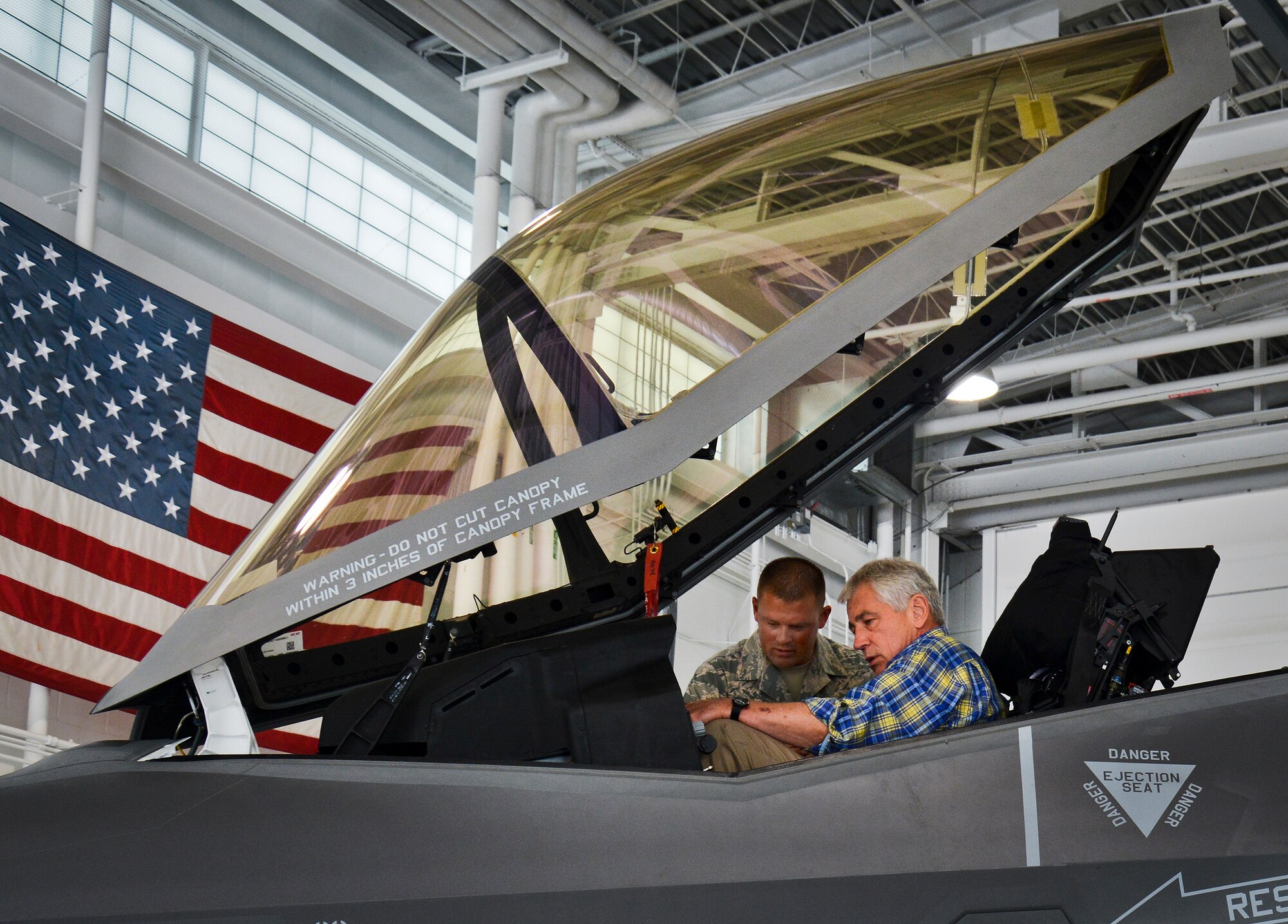 Tech. Sgt. Michael McClure, 33rd Aircraft Maintenance Squadron, briefs Defense Secretary Chuck Hagel on the cockpit of the F-35A Lightning II July 10 at Eglin Air Force Base, Fla.  Hagel visited the base to tour the 33rd Fighter Wing and F-35 Lightning II integrated training center.  He held a 45-minute troop call to praise the work of the service members who began and continue to improve the DOD’s newest fighter program.  (U.S. Air Force photo/Linda Phillips)