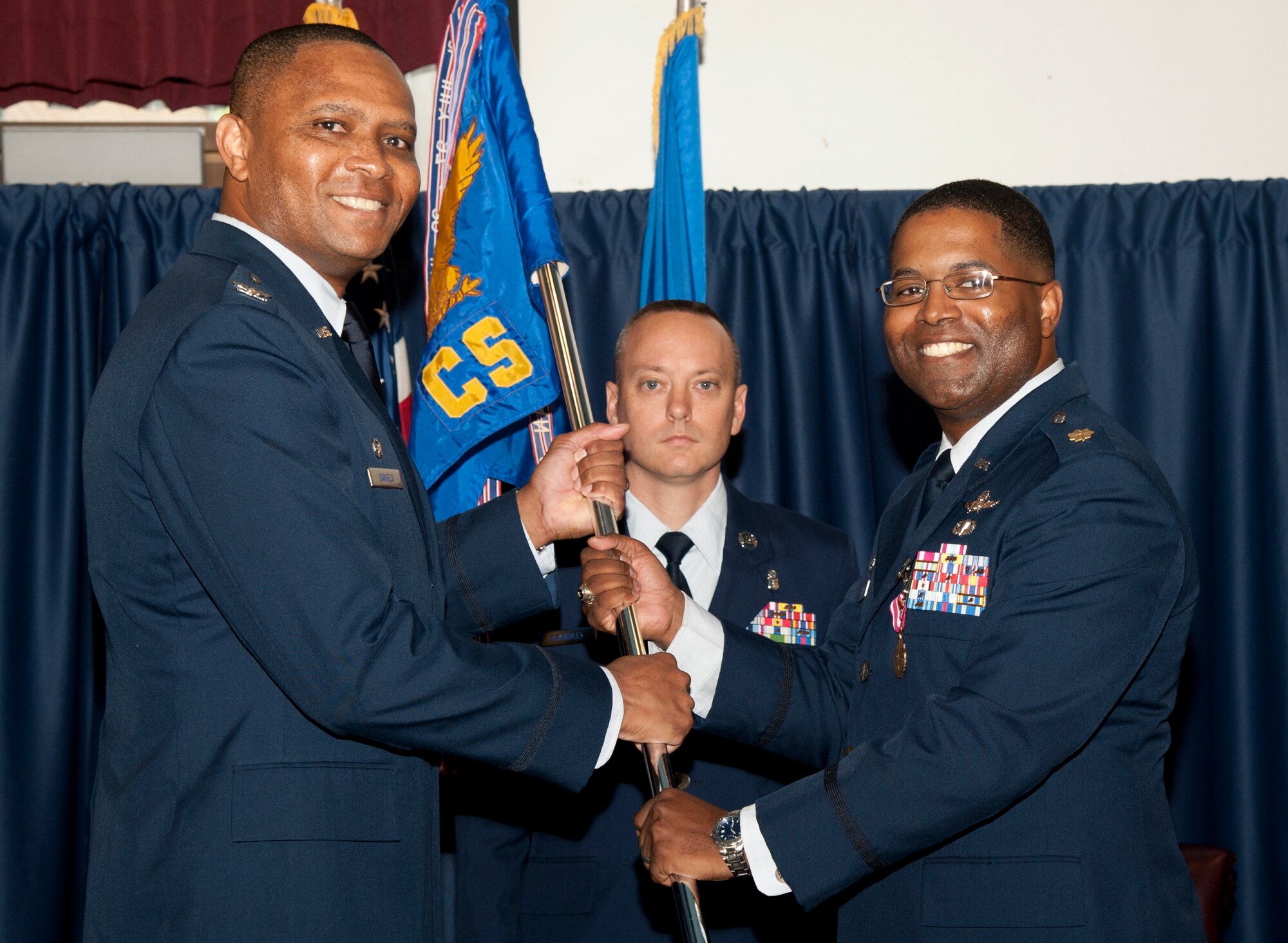VANCE AIR FORCE BASE, Okla. – Maj. Lavant Morrow (left), the 71st Communications Squadron commander, hands the 71st CS guidon to Col. Christopher Daniels, the 71st Mission Support Group commander, during a relinquishment-of-command ceremony July 10 at the Vance Collocated Club. Morrow is the final commander of the 71st CS. The squadron is scheduled to drawn down to a flight later this month. (U.S. Air Force photo/Staff Sgt. James Bolinger)