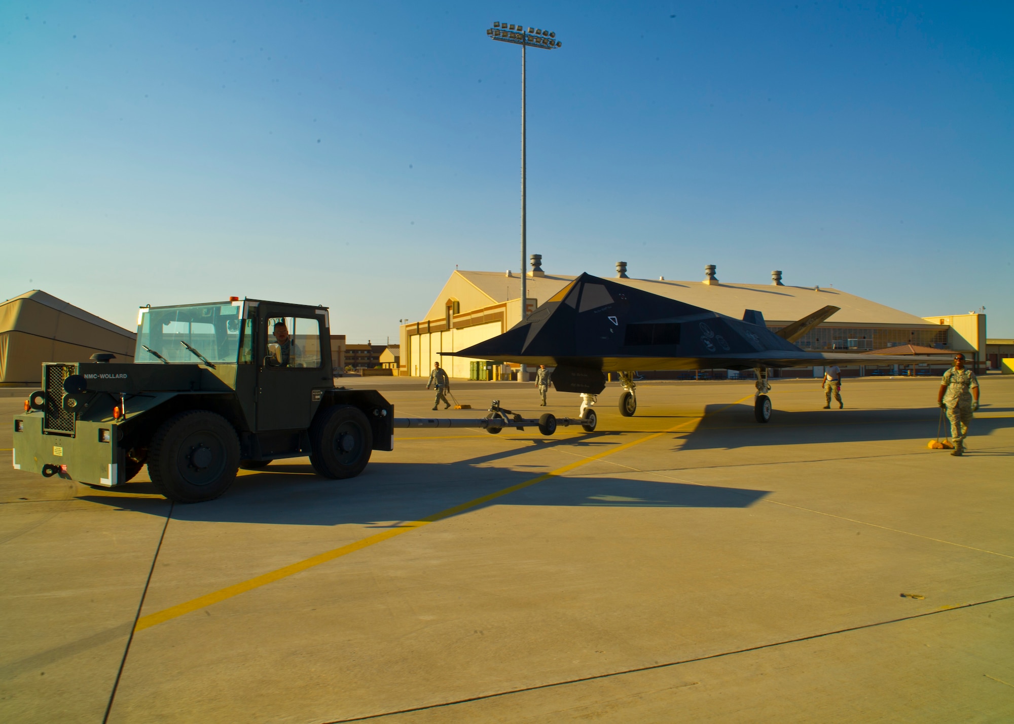 Members of Team Holloman start the towing process of the F-117 Nighthawk back to Heritage Airpark at Holloman Air Force Base, N.M., June 28. The F-117 has been on static display in Holloman’s Heritage Airpark since its retirement in 2008. Due to sun and inclement weather damage, the 49th Maintenance Squadron removed and towed the aircraft to begin the restoration process. The aircraft received structural maintenance, and a fresh paint job before it was returned for display in Heritage Airpark. (U.S. Air Force photo by Airman 1st Class Leah Ferrante/Released)