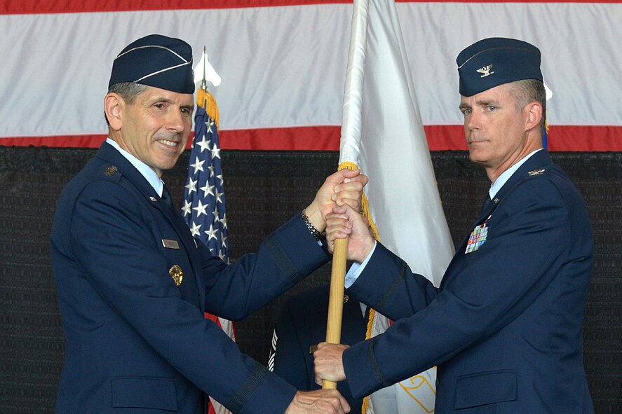 HANSCOM AIR FORCE BASE, Mass. – Lt. Gen. C. D. Moore II, Air Force Life Cycle Management Center commander, passes the guidon to Col. Michael A. Vogel, new 66th Air Base Group commander, during the 66th Air Base Group Change of Command ceremony at the Hanscom Aero Club Hangar July 10. Vogel assumed command from Col. Lester A. Weilacher who is transferring to Langley Air Force Base, Va. (U.S. Air Force photo by Walter Santos 
