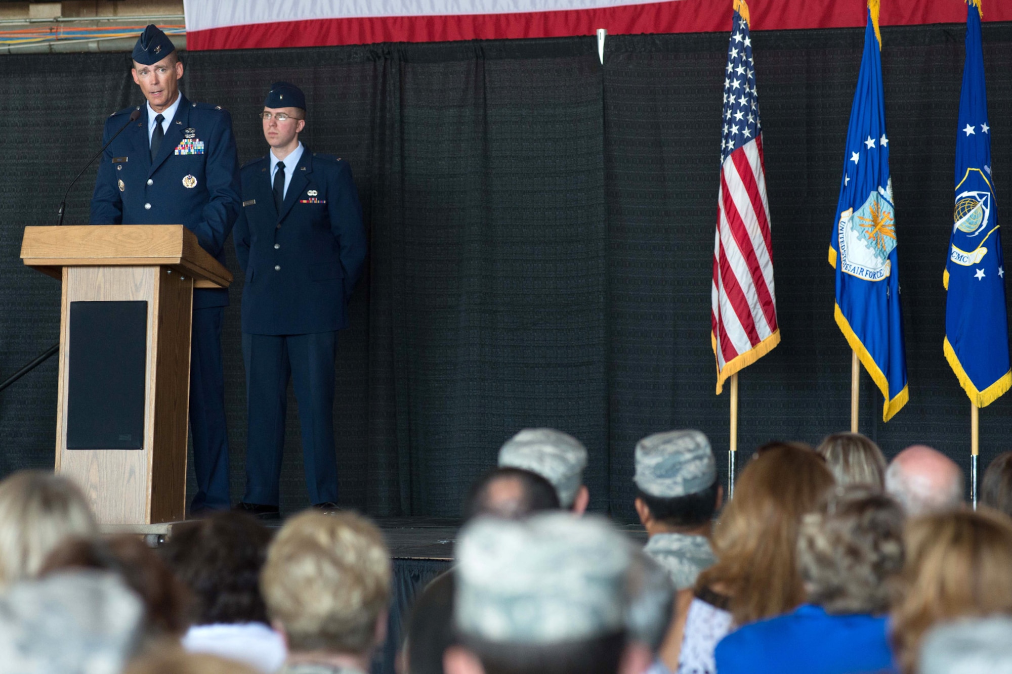 HANSCOM AIR FORCE BASE, Mass. – Col. Michael A. Vogel, new 66th Air Base Group commander, speaks to the audience during the 66th Air Base Group Change of Command ceremony at the Hanscom Aero Club Hangar July 10, while 1st Lt. Daniel Langston, 66th Air Base Group executive officer and narrator for the ceremony, looks on. Vogel assumed command from Col. Lester A. Weilacher who is transferring to Langley Air Force Base. (U.S. Air Force photo by Walter Santos)   