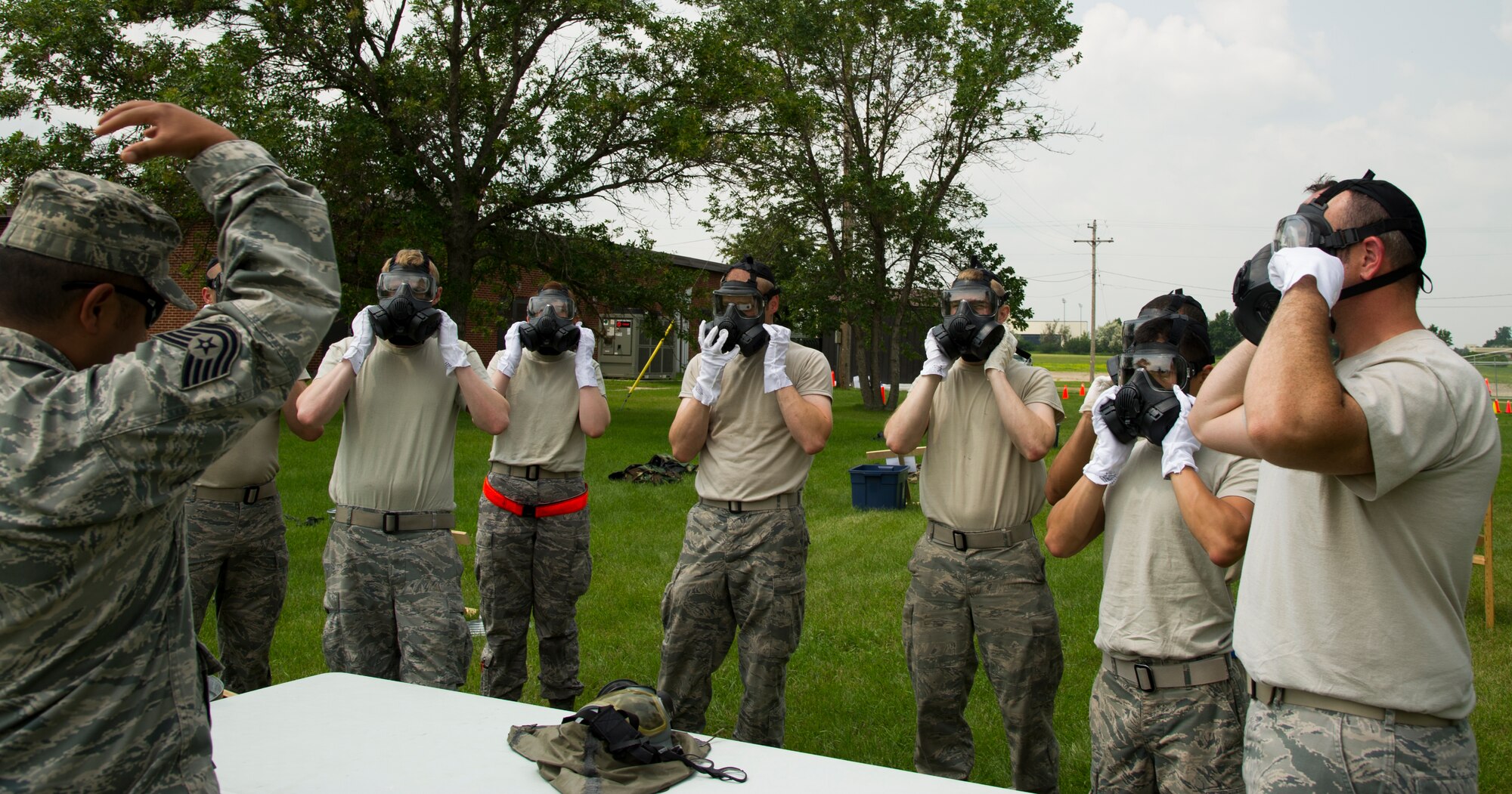 Airmen from the 5th Aircraft Maintenance Squadron prepare to take off their gas-masks during one of the last steps of an Ability to Survive and Operate Training course on Minot Air Force Base, N.D., July 8, 2014. The training was conducted to teach Airmen how to safely add and take off gear. (U.S. Air Force photo/Senior Airman Andrew Crawford)